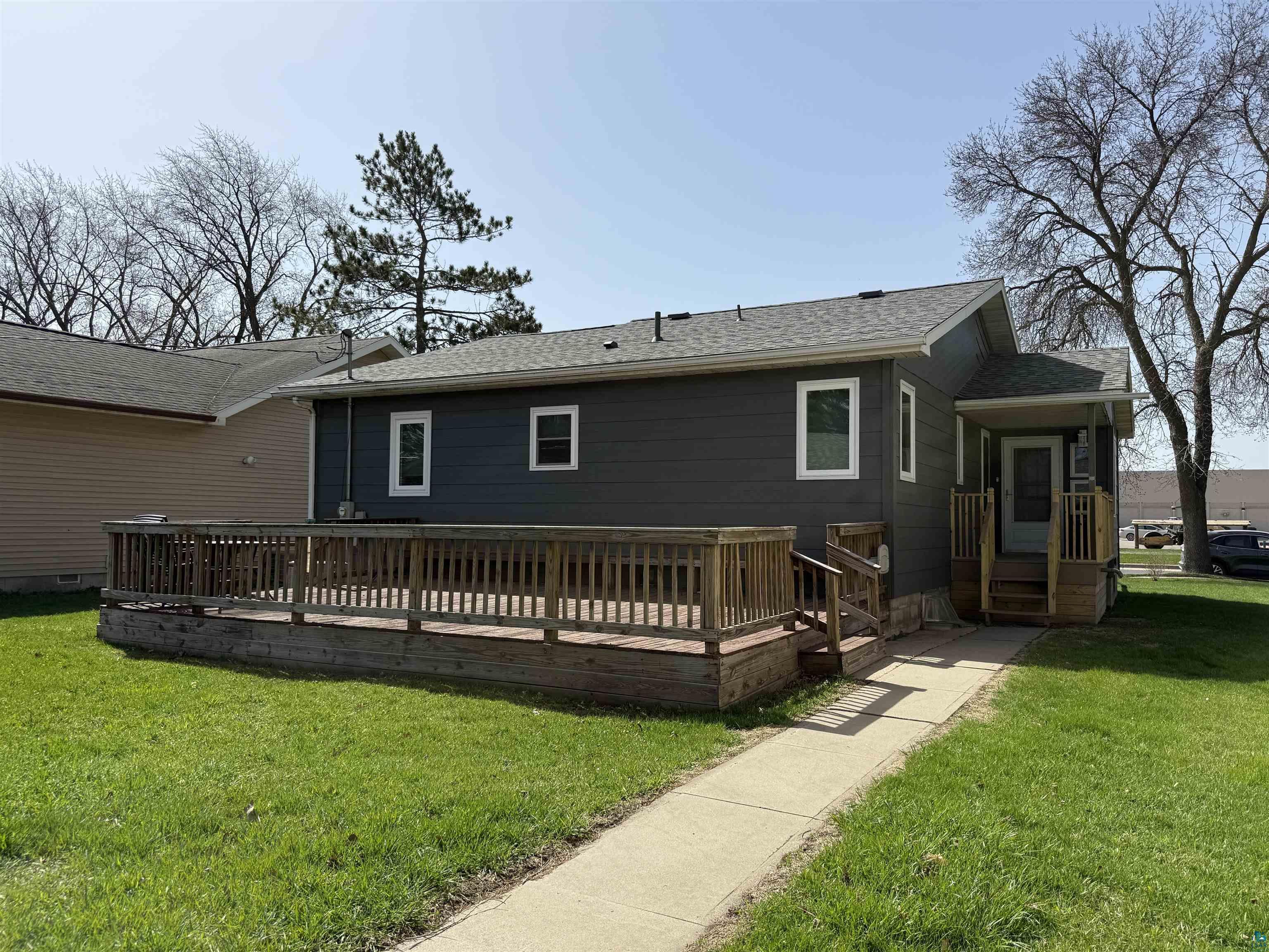 1321 South 13th Street Virginia, MN 55792 - Photo 27 of 33 Exterior featuring charcoal gray siding, white-framed windows, a covered front entry with steps, and an expansive wooden deck