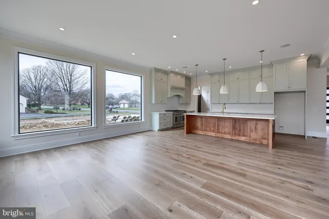 a kitchen with stainless steel appliances granite countertop a sink a stove and a wooden floors