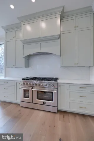 an empty room with wooden floor ceiling fan and window