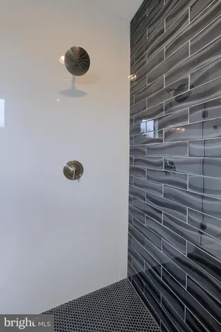 a spacious bathroom with a granite countertop sink and mirror with bathtub
