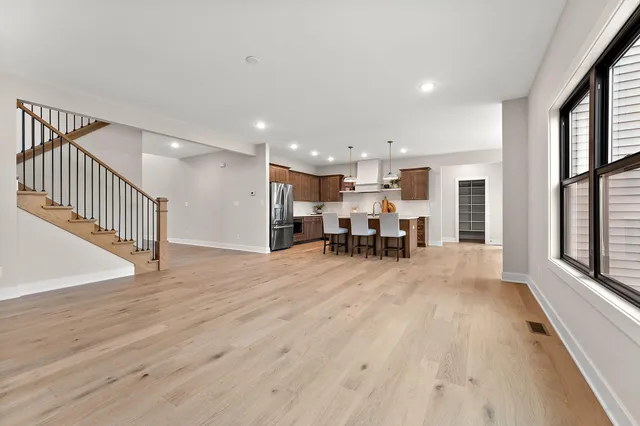 a view of a big room with wooden floor and windows