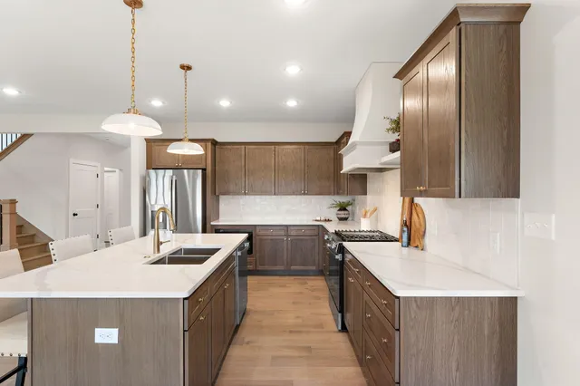 a kitchen with a stove a sink a refrigerator and a oven