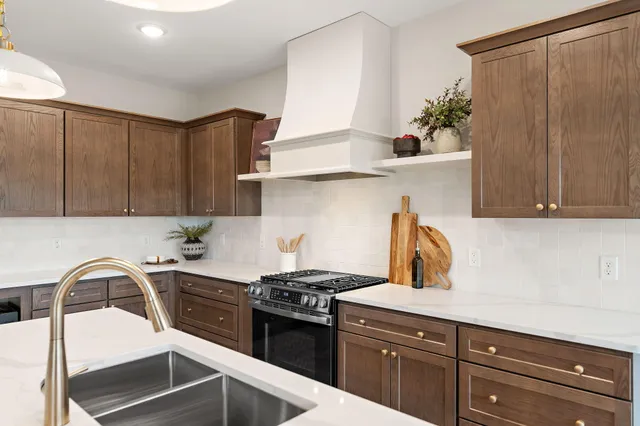 a kitchen with stainless steel appliances a sink a stove and cabinets