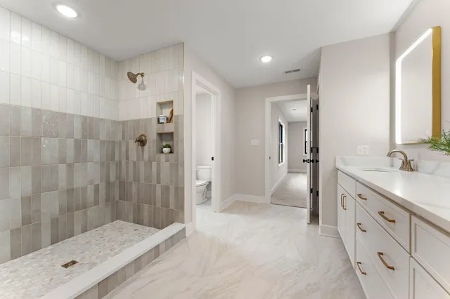 a bathroom with a granite countertop sink a mirror a shower and a bathtub