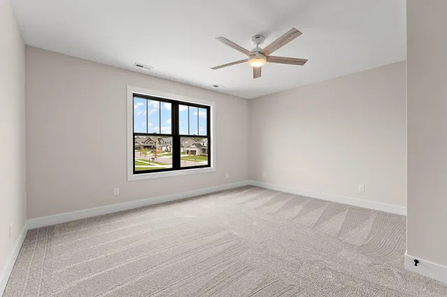 an empty room with windows and ceiling fan view