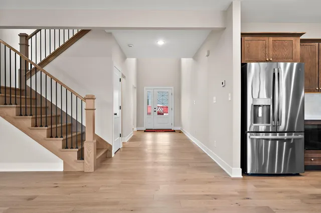 a view of hallway with stairs and wooden floor
