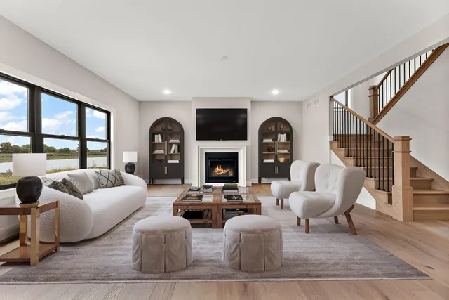 a living room with furniture fireplace and a large window
