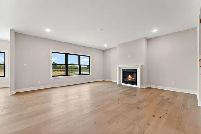 a view of an empty room with a window and fireplace