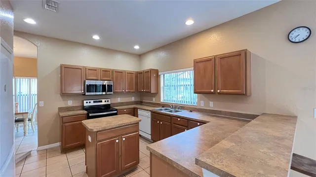 a kitchen with kitchen island a sink stove and refrigerator