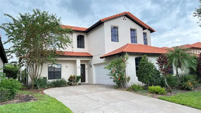 a view of a house with potted plants and a yard