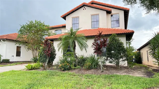 a view of a house with a yard and potted plants