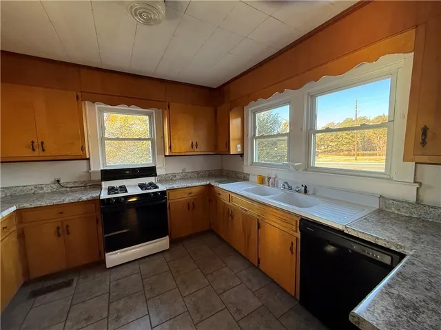 a kitchen with stainless steel appliances granite countertop a sink stove and cabinets