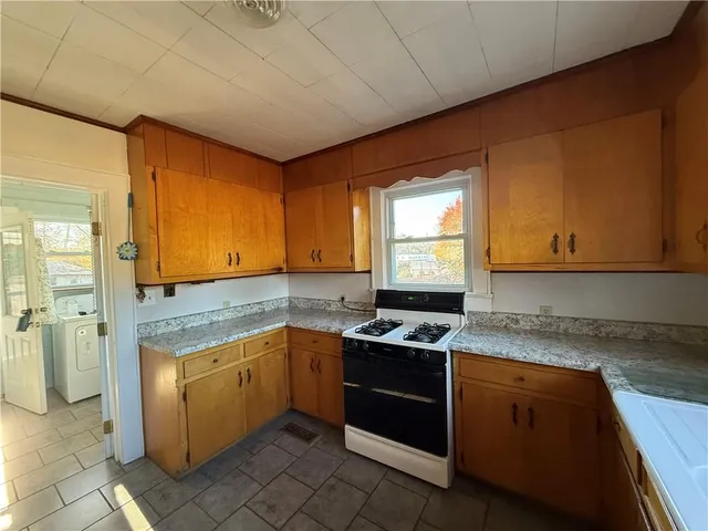 a kitchen with a stove sink and cabinets