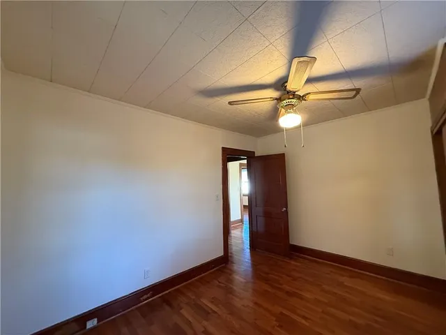 a view of an empty room with a fan and a window