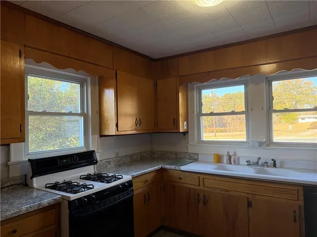 a kitchen with stainless steel appliances granite countertop a sink stove and cabinets