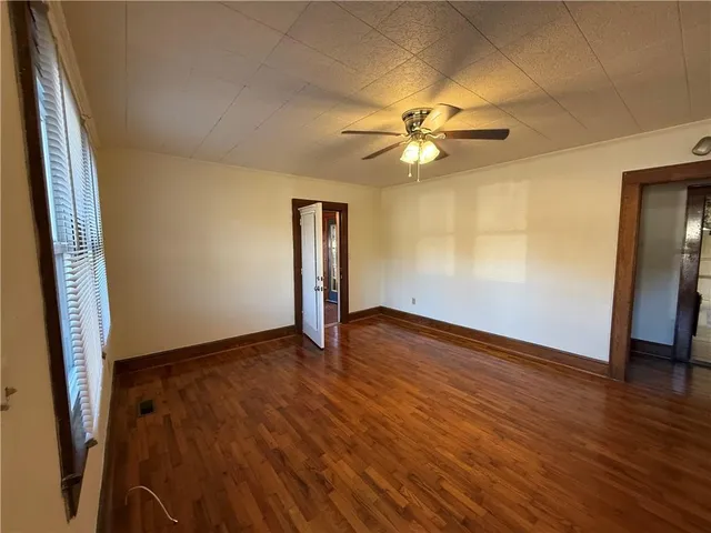 an empty room with wooden floor and door