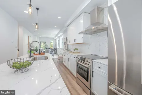 a outdoor kitchen with white cabinets and stainless steel appliances
