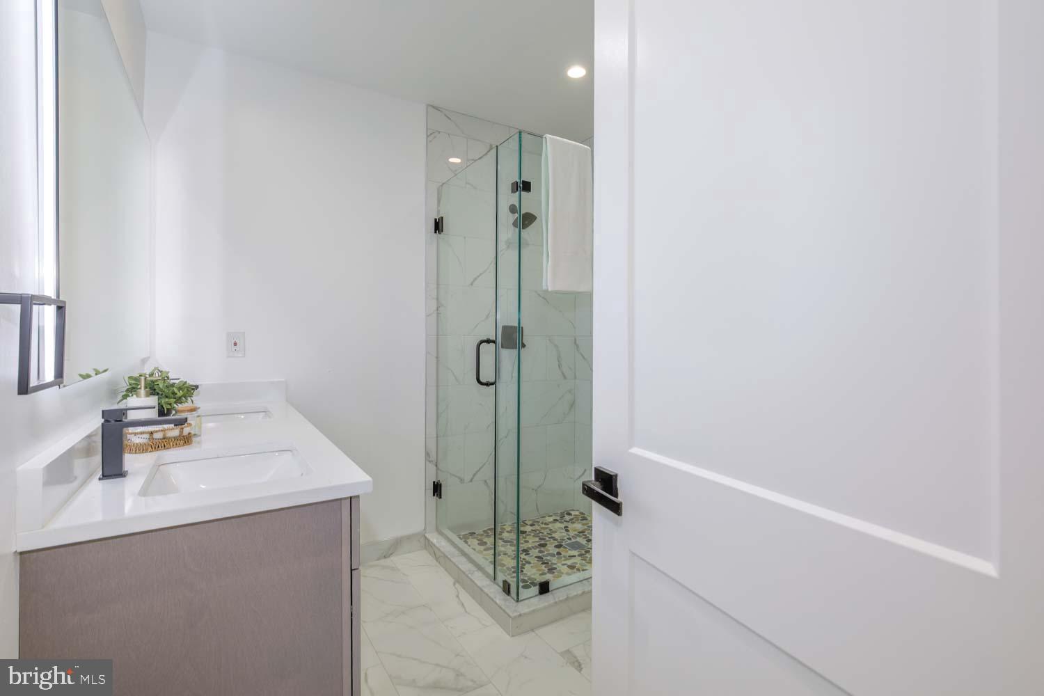 424 Taylor Street Northwest, Unit 1 Washington, DC 20011 - Photo 37 of 53 a bathroom with a granite countertop sink a mirror and shower