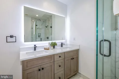 a view of a room that has a bed and mirror in it