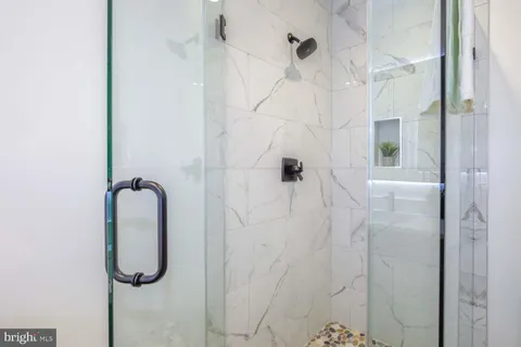 a bathroom with a granite countertop sink toilet a mirror and shower