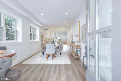a dining room with a table chairs and a kitchen view