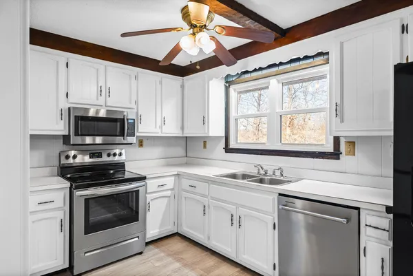 a kitchen with stainless steel appliances white cabinets and a sink