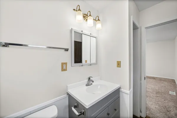 a bathroom with a sink toilet and mirror
