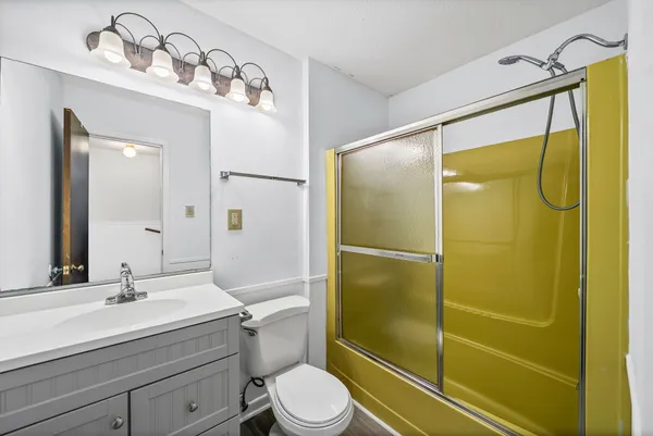 a bathroom with a sink mirror toilet and shower