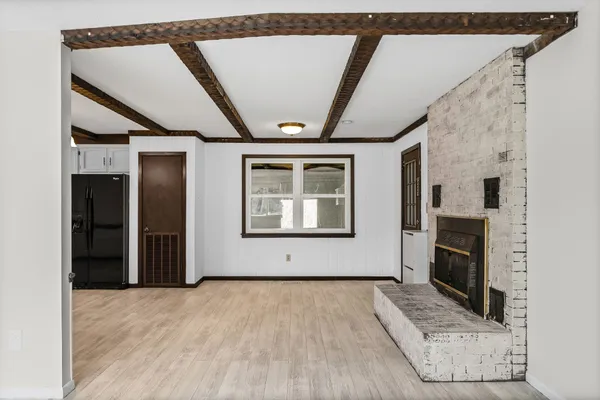 a view of an empty room with a fireplace and a window