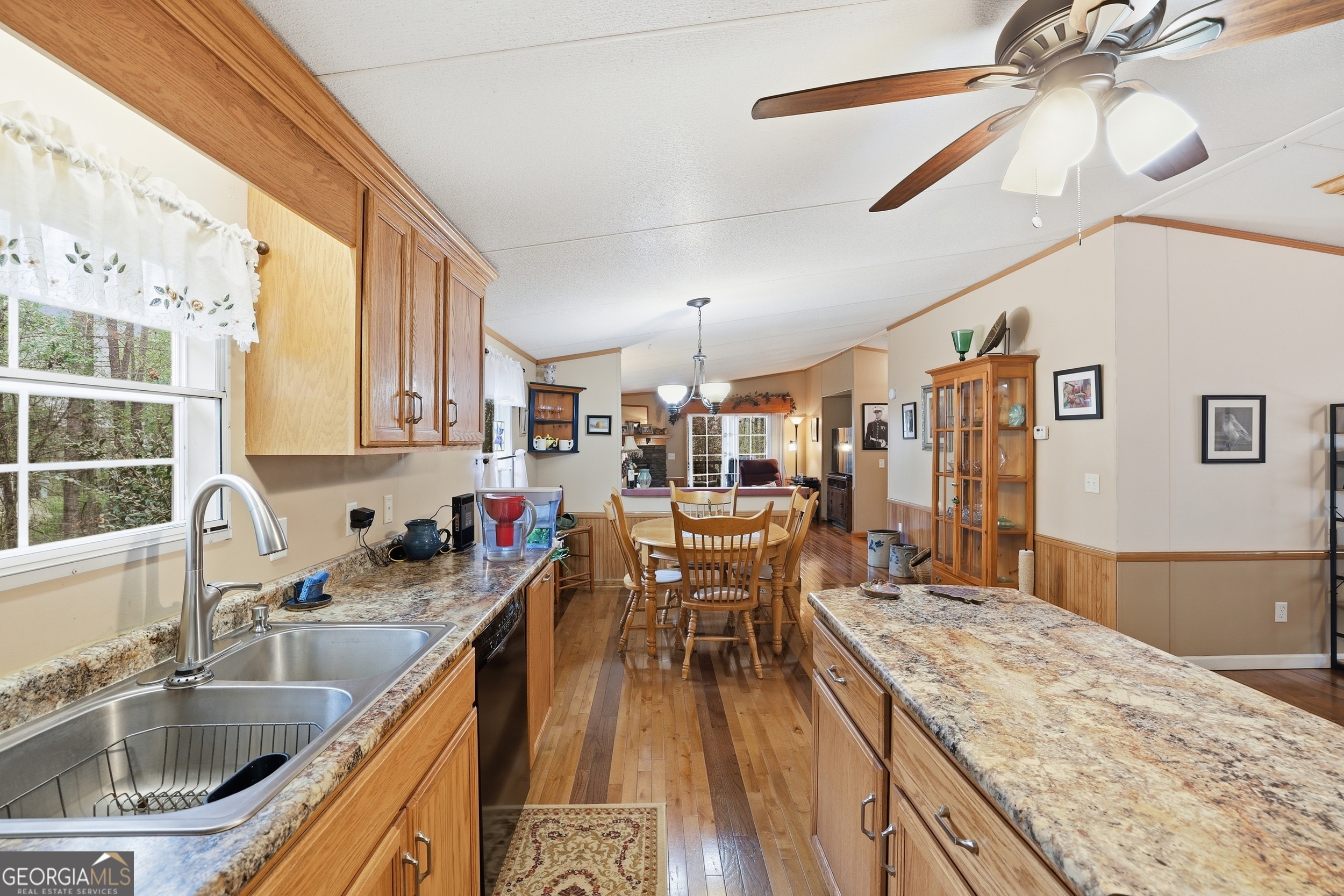 2533 McFarlin Bridge Road Carnesville, GA 30521 - Photo 12 of 37 a kitchen with a sink a counter space dining table and chairs