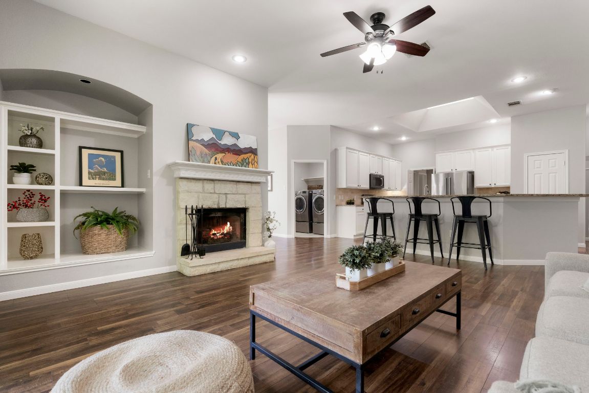 a living room with furniture a fireplace and kitchen view