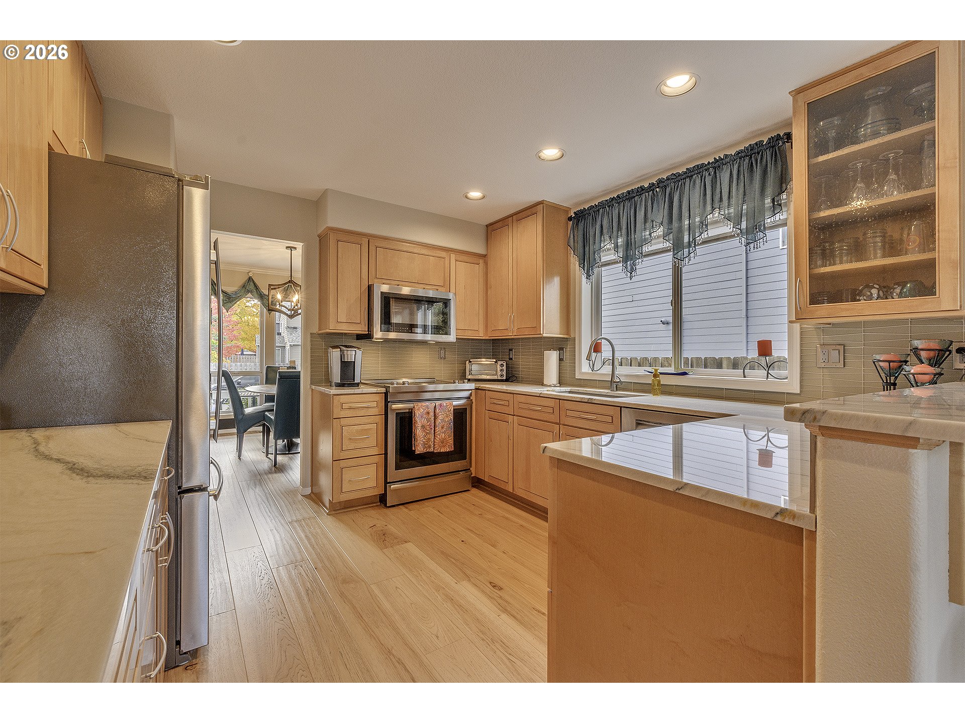 16761 Northwest Stoller Drive Portland, OR 97229 - Photo 9 of 35 a kitchen with stainless steel appliances granite countertop a refrigerator a sink dishwasher a stove and white countertops with wooden floor