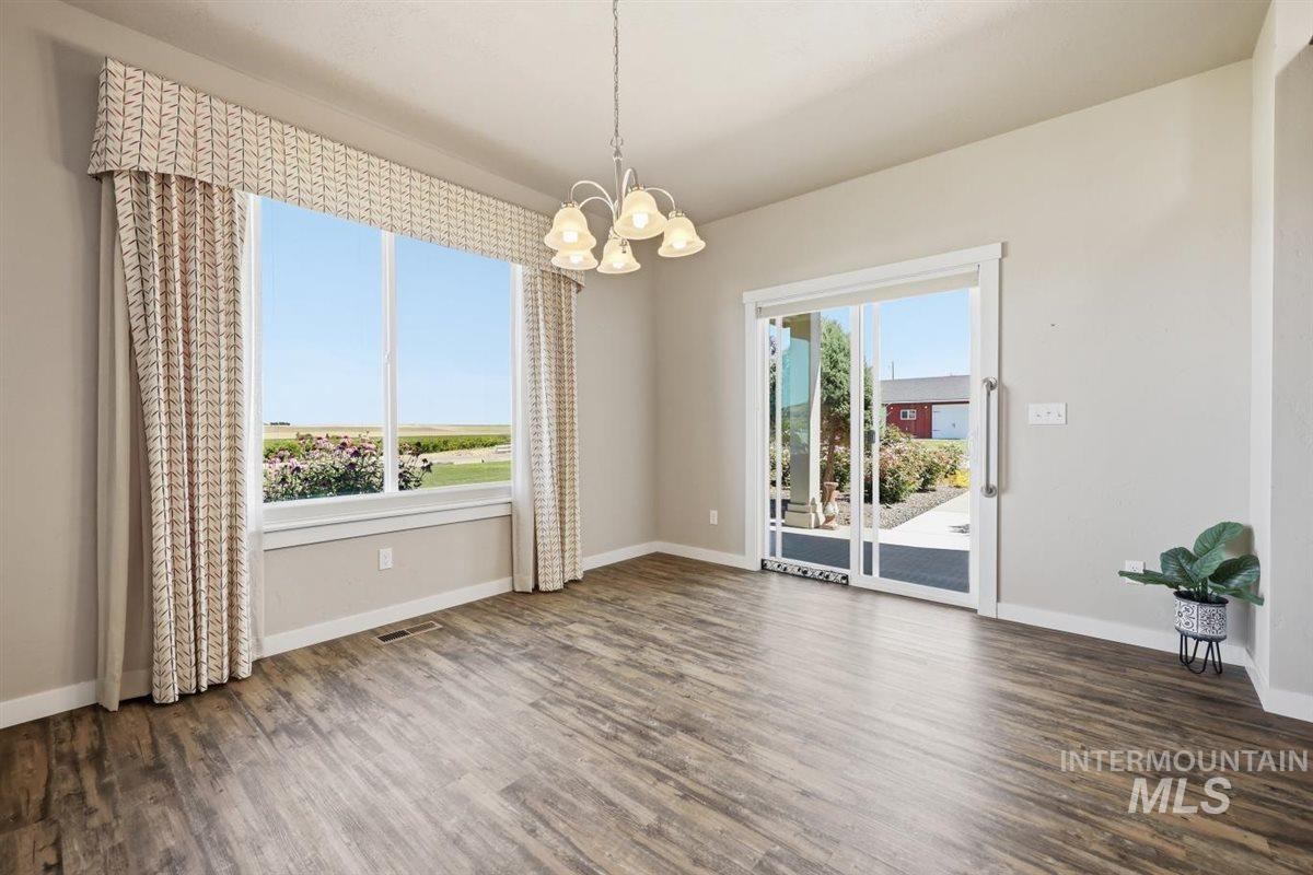 13496 Hockberger Ranch Road Caldwell, ID 83607 - Photo 14 of 40 Spacious room featuring wood-finish flooring, a large picture window, and a sliding glass door