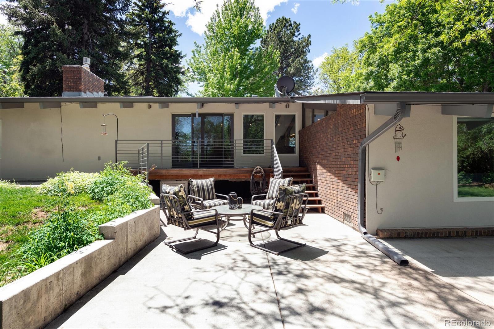 4595 West Lakeridge Road Denver, CO 80219 - Photo 36 of 45 a view of a patio with table and chairs with wooden floor and fence