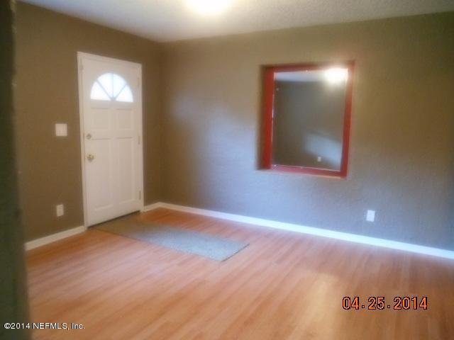 10633 Rutgers Road Jacksonville, FL 32218 - Photo 2 of 11 a view of an empty room with wooden floor and a window