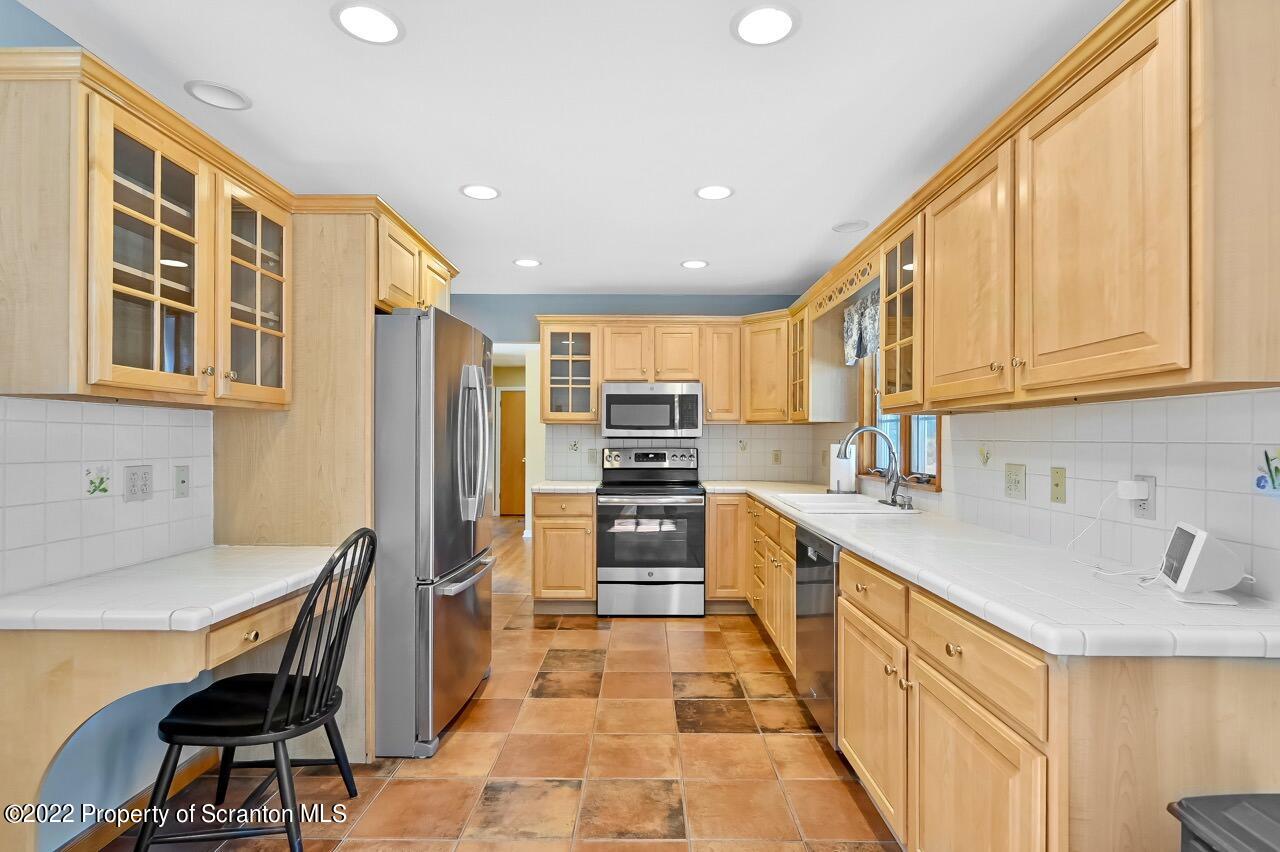 104 Fern Lane Moscow, PA 18444 - Photo 15 of 44 a kitchen with stainless steel appliances granite countertop a refrigerator and a stove top oven