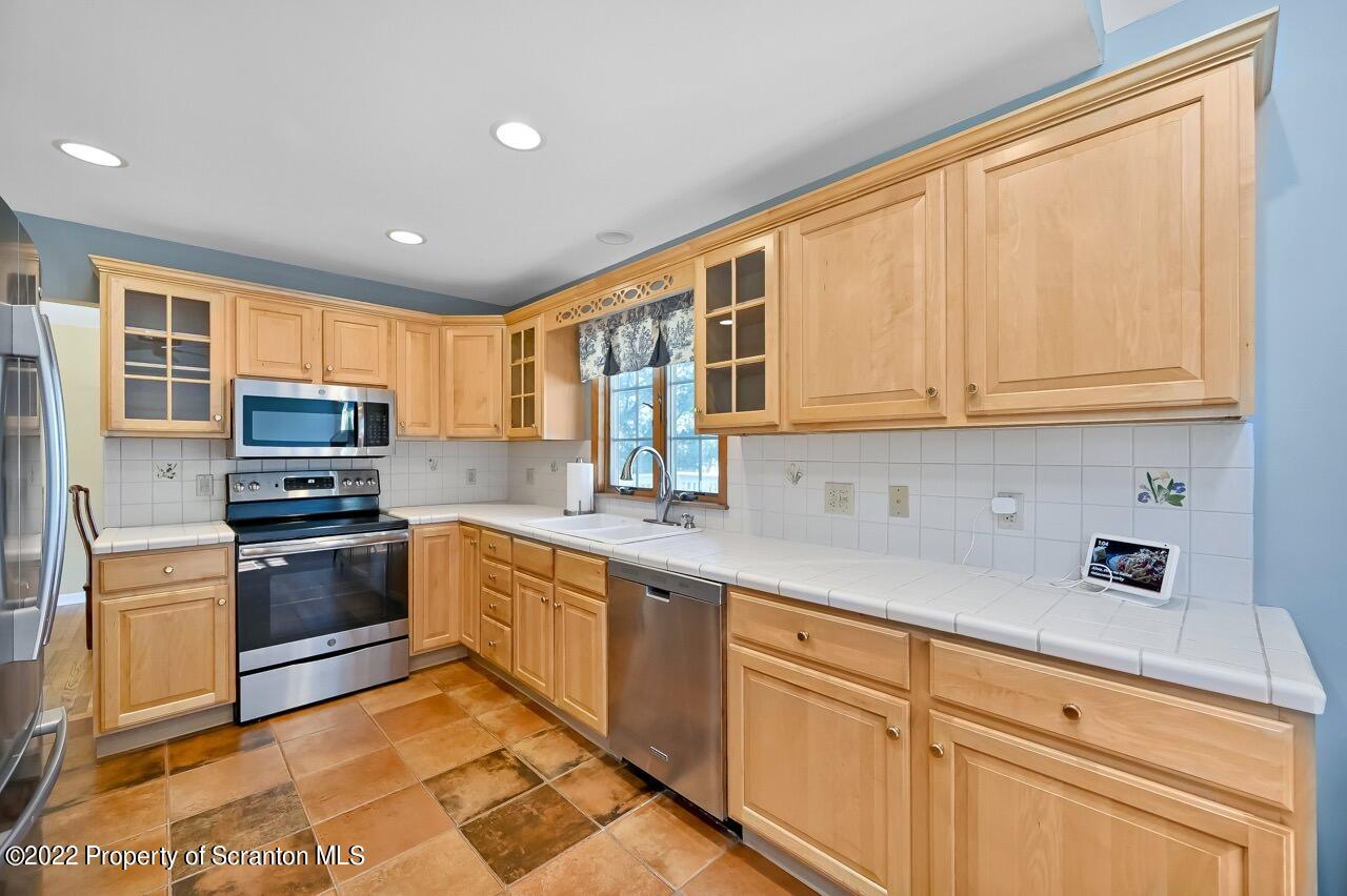 104 Fern Lane Moscow, PA 18444 - Photo 16 of 44 a kitchen with stainless steel appliances granite countertop a stove sink microwave and cabinets