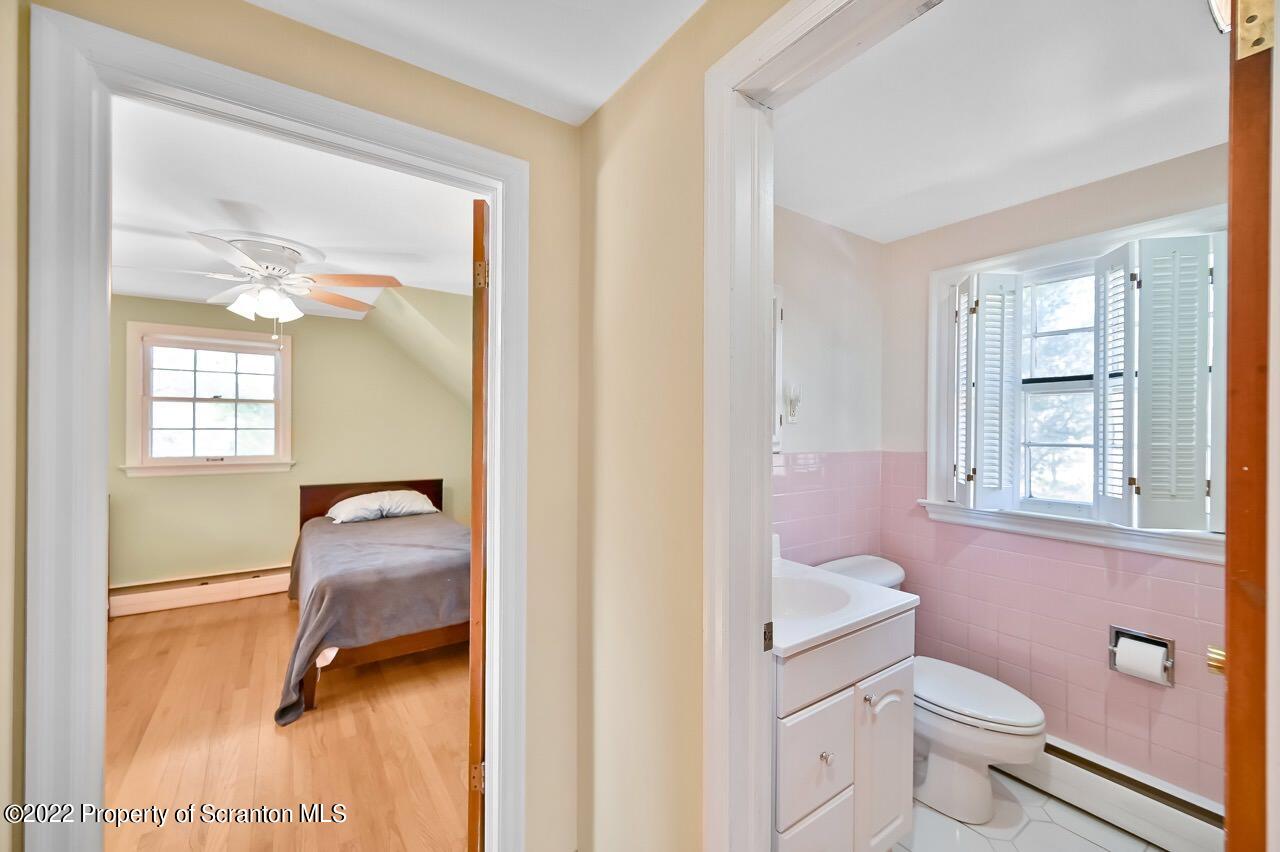 104 Fern Lane Moscow, PA 18444 - Photo 31 of 44 a bathroom with a granite countertop toilet a sink and a mirror