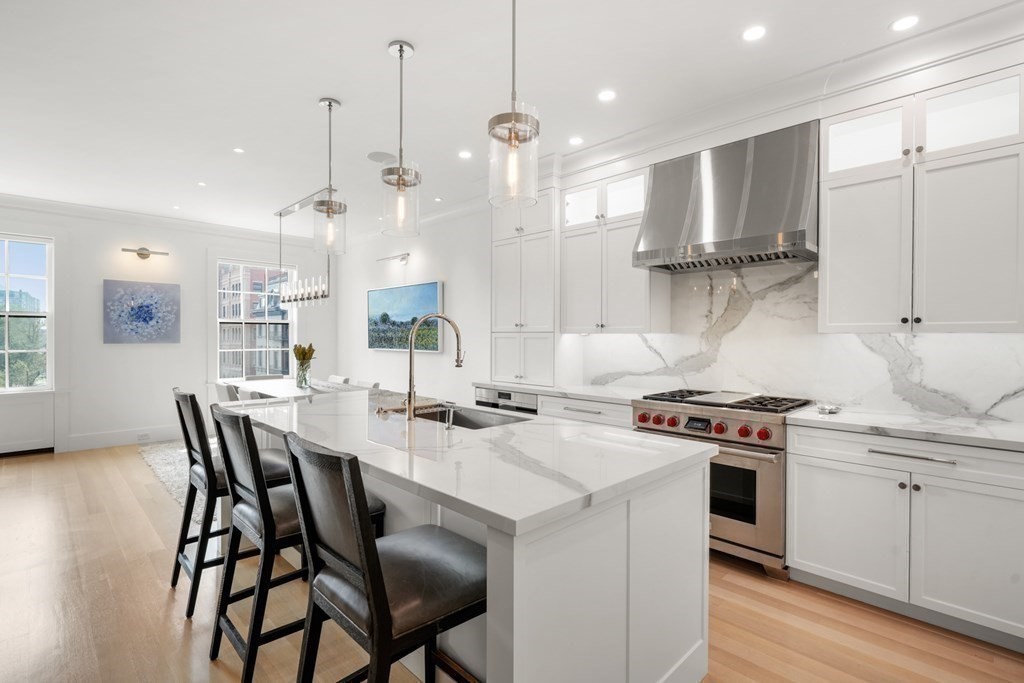 94 Beacon Street, Unit 4 Boston, MA 02108 - Photo 12 of 35 a kitchen with stainless steel appliances granite countertop a stove a refrigerator a sink a dining table and chairs with wooden floor