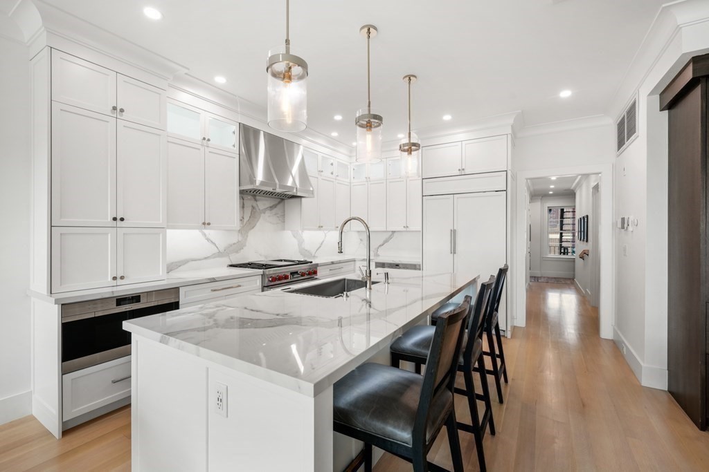94 Beacon Street, Unit 4 Boston, MA 02108 - Photo 3 of 35 a kitchen with stainless steel appliances granite countertop a stove a sink a refrigerator and a dining table with wooden floor