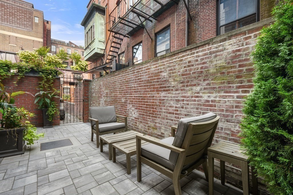 94 Beacon Street, Unit 4 Boston, MA 02108 - Photo 31 of 35 a brick building with a bench and a potted plant