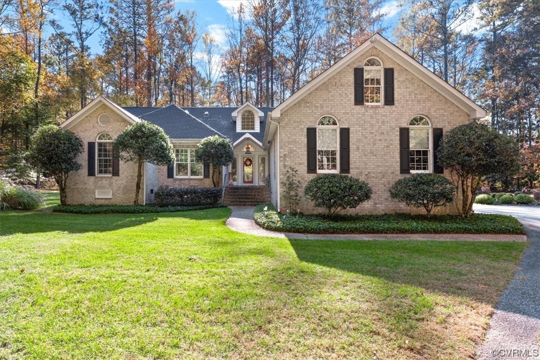 a view of a white house next to a yard with big trees