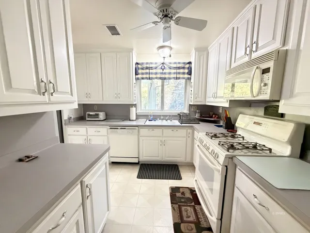 a kitchen with granite countertop a sink stainless steel appliances and cabinets