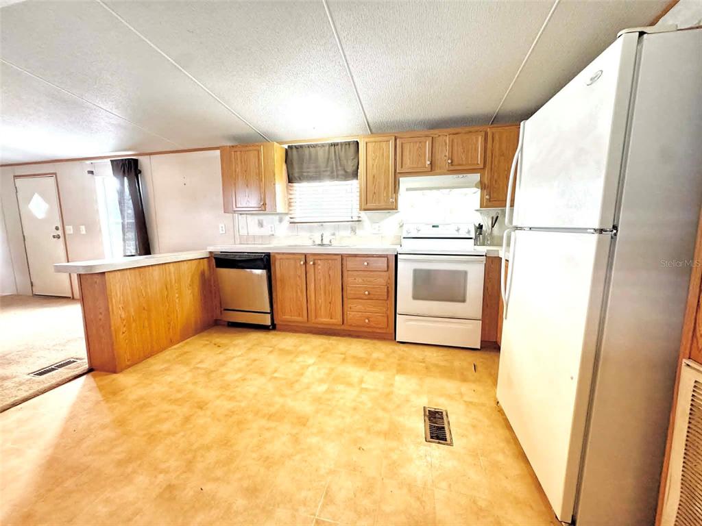 612 Morgan Road Winter Haven, FL 33880 - Photo 8 of 38 a kitchen with stainless steel appliances granite countertop a refrigerator a stove and a sink