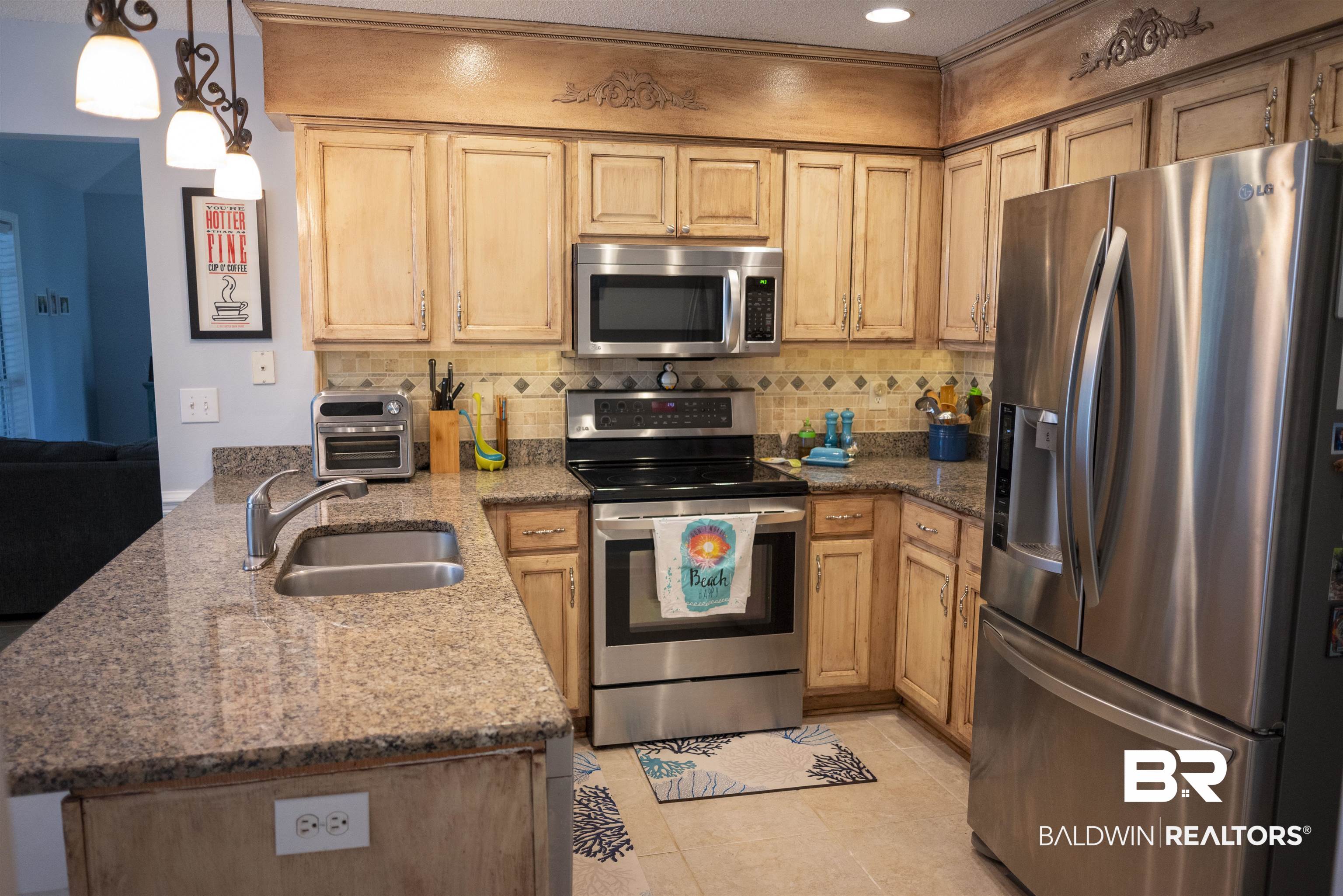 808 Wisteria Lane Foley, AL 36535 - Photo 6 of 19 Kitchen with dark stone counters, light tile patterned flooring, sink, appliances with stainless steel finishes, and decorative light fixtures