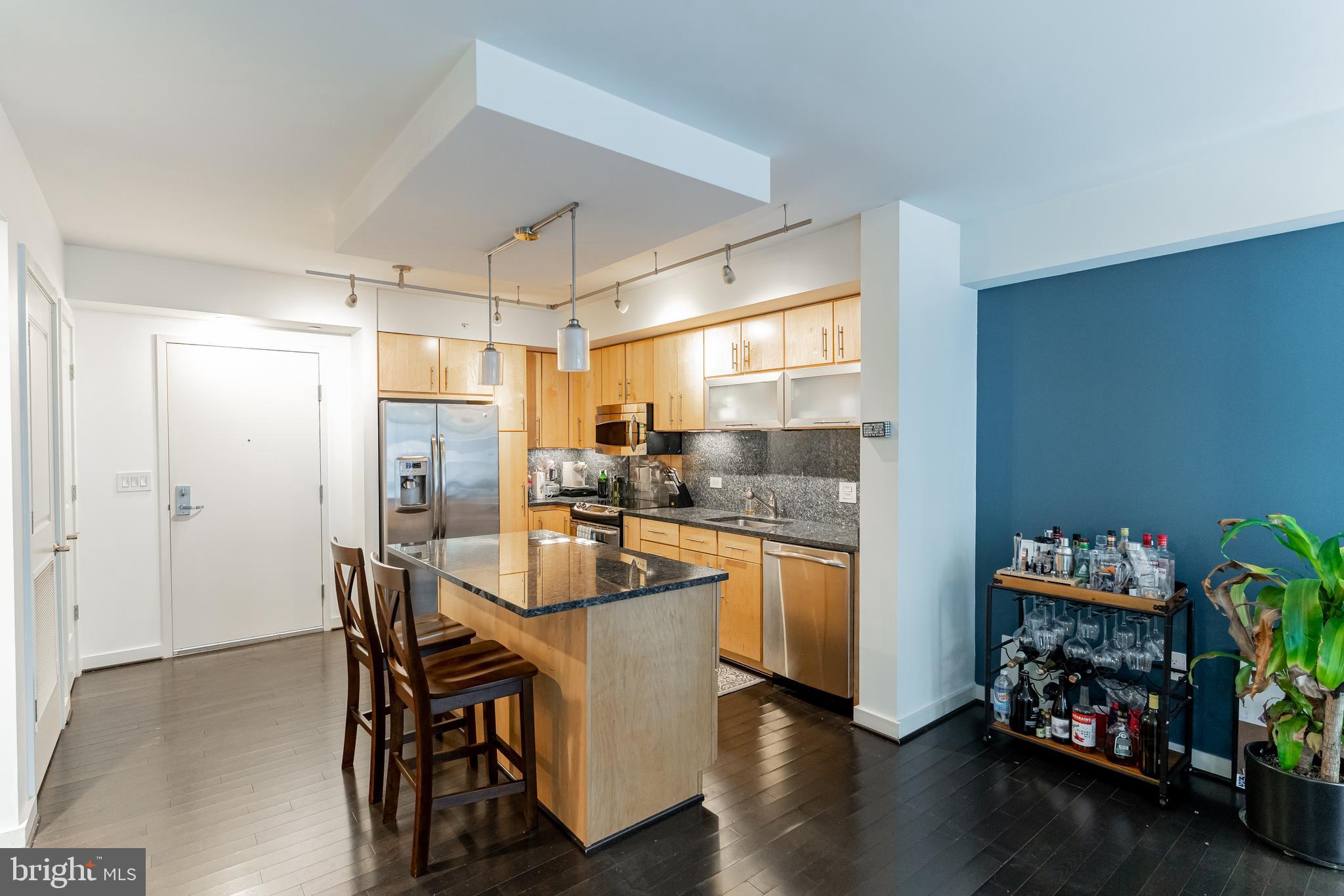 1025 First Street Southeast, Unit 514 Washington, DC 20003 - Photo 4 of 15 a kitchen with stainless steel appliances a dining table chairs and chandelier