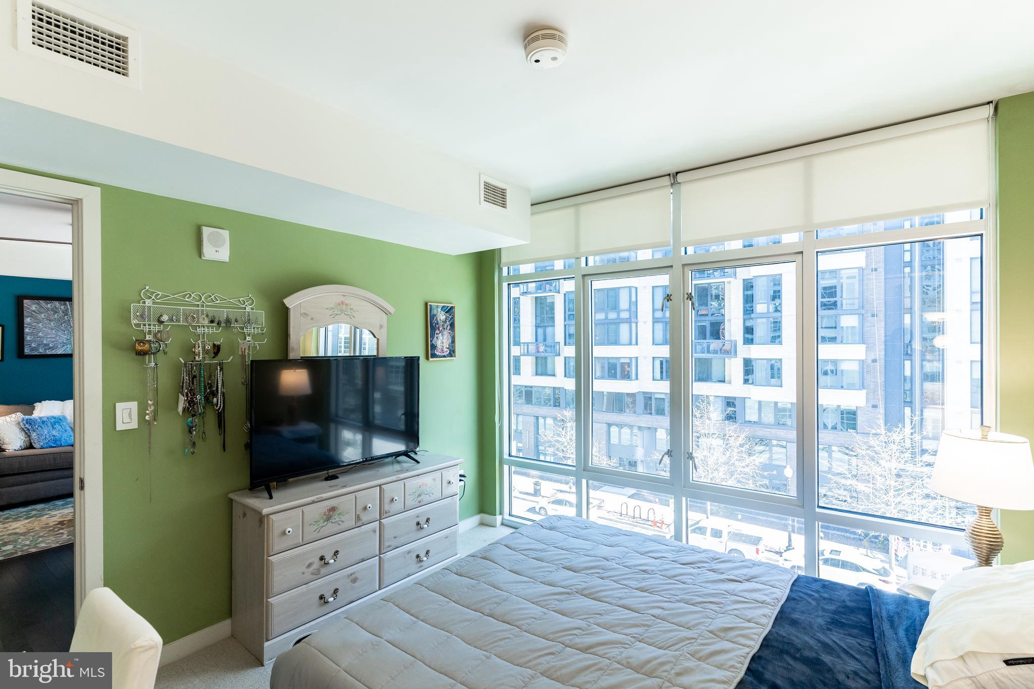 1025 First Street Southeast, Unit 514 Washington, DC 20003 - Photo 9 of 15 a spacious bedroom with a bed and a flat screen tv