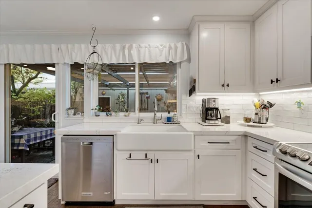 a kitchen with kitchen island granite countertop white cabinets and white appliances