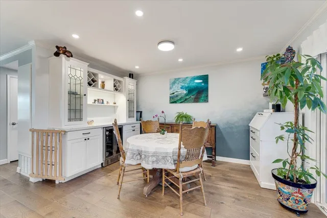 a view of a dining room with furniture potted plants and wooden floor