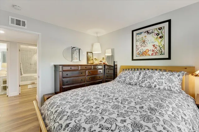 a bedroom with a bed and a painting on the wall